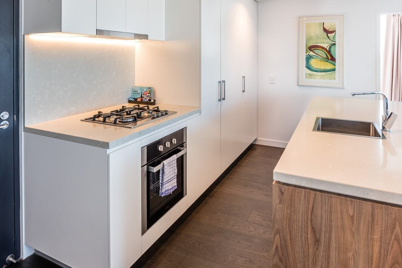 A modern kitchen with a gas stove, oven, and a sink.