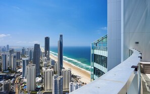 Um edifício alto com vista para a praia e o oceano.