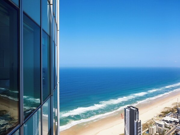 A high-rise building with a view of the ocean and beach.