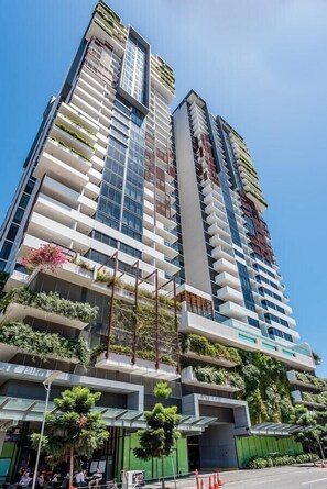 A high-rise building with multiple balconies, some with plants, and a modern architectural design. - 1 bedroom Home in Heart South Brisbane+Parking (South Brisbane)