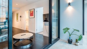 Un interior moderno con una mesa redonda, una puerta de cristal y plantas en macetas.