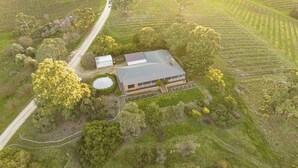 An aerial view of a property with a large building, surrounded by lush greenery and fields. - The Hideaway by Gatt Wines (Flaxman Valley)