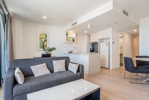 Relax in this stylish living area with a sofa, coffee table, and kitchenette.