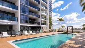 Un hôtel moderne doté d’une piscine sur le toit, de nombreux balcons et de chaises longues.