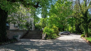 Ein Pflasterweg führt zu einem Gebäude mit Treppen und einer Statue.