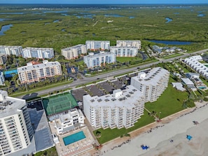 Un hotel moderno de gran altura con varias plantas, piscina y zona de playa.