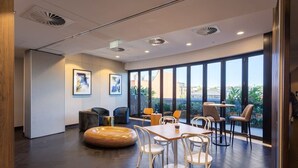 Un interior moderno con un ventanal grande, una zona de estar circular y una mesa con sillas.