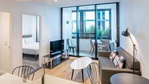 A modern living room with a TV, sofa, and dining area.