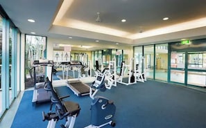 A gym with treadmills, weight machines, and exercise mats.