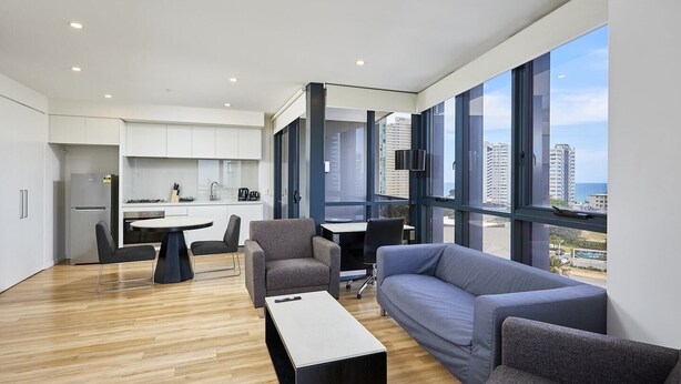 Eine moderne Wohnung mit Küche, Essbereich und Sitzgelegenheit mit Blick auf die Stadt.