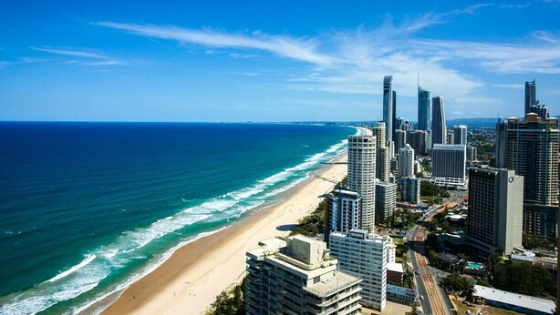Eine Küstenstadt mit Hochhäusern, einem Strand und blauem Himmel.