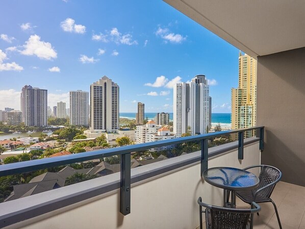 A balcony with a view of a cityscape and the ocean. - Partially Oceanview 2 bedroom apartment in Surfers (Surfers Paradise)
