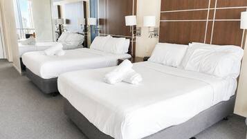 A hotel room with two beds, a large mirror, and a view of the city.