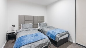 Un dormitorio con dos camas, una mesita de noche y un armario.