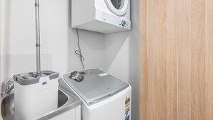Un área de lavandería con lavadora, secadora y una máquina fregadora.