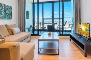 A modern living room with a sofa, coffee table, and television.