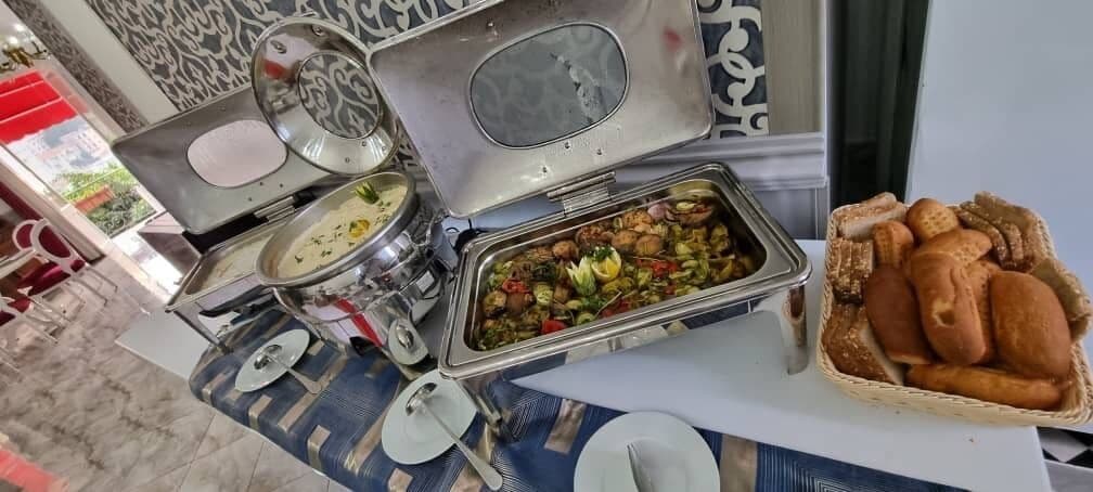 A buffet setup with various dishes and bread baskets.