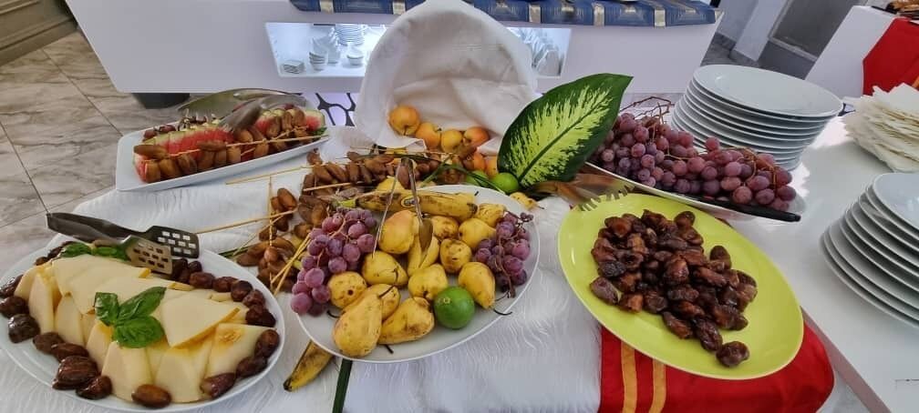 Une table de buffet proposant divers aliments, notamment des fruits, des noix et du fromage.