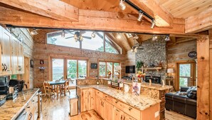 Une cuisine spacieuse avec des meubles en bois, un plan de travail en granit et une cheminée en pierre.