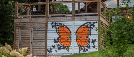 A wooden structure with a large butterfly mural on the side.