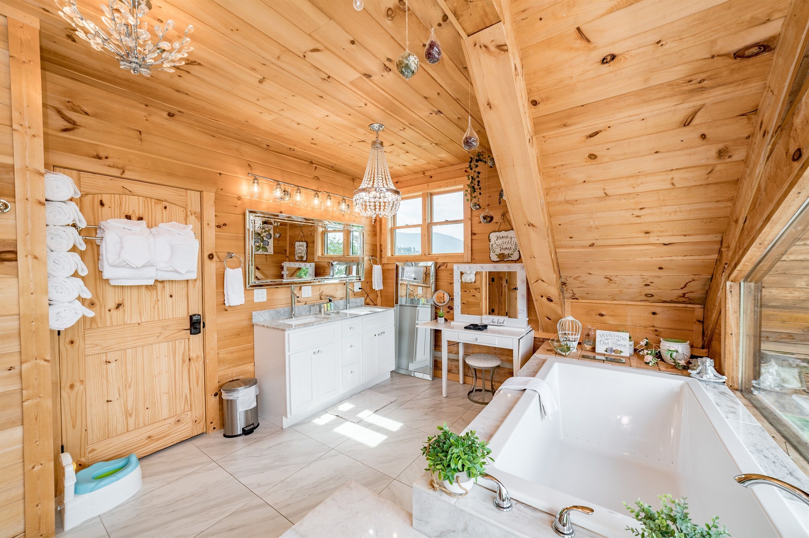 A wooden cabin interior with a bathroom featuring a bathtub, a sink, and a vanity.