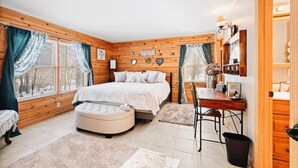 A cozy bedroom with a bed, a desk, and a chair. There are curtains, a lamp, and a shelf with decorative items.