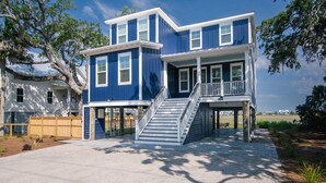 A two-story house with a front porch, a staircase, and a fenced yard.