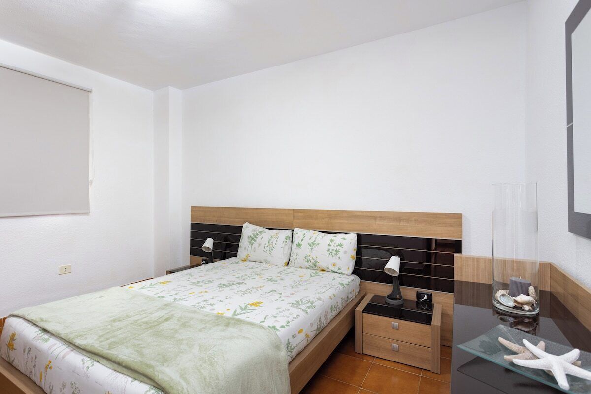 Ein Schlafzimmer mit Bett, Nachttischen und einem Spiegel.