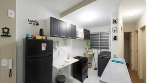 A compact kitchen with a refrigerator, stove, sink, and cabinets. - Apartamento Park Quinet  (Juiz de Fora)