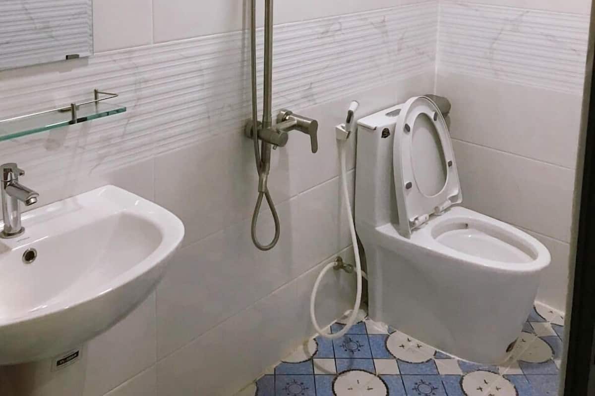 A bathroom with a shower, toilet, and sink.