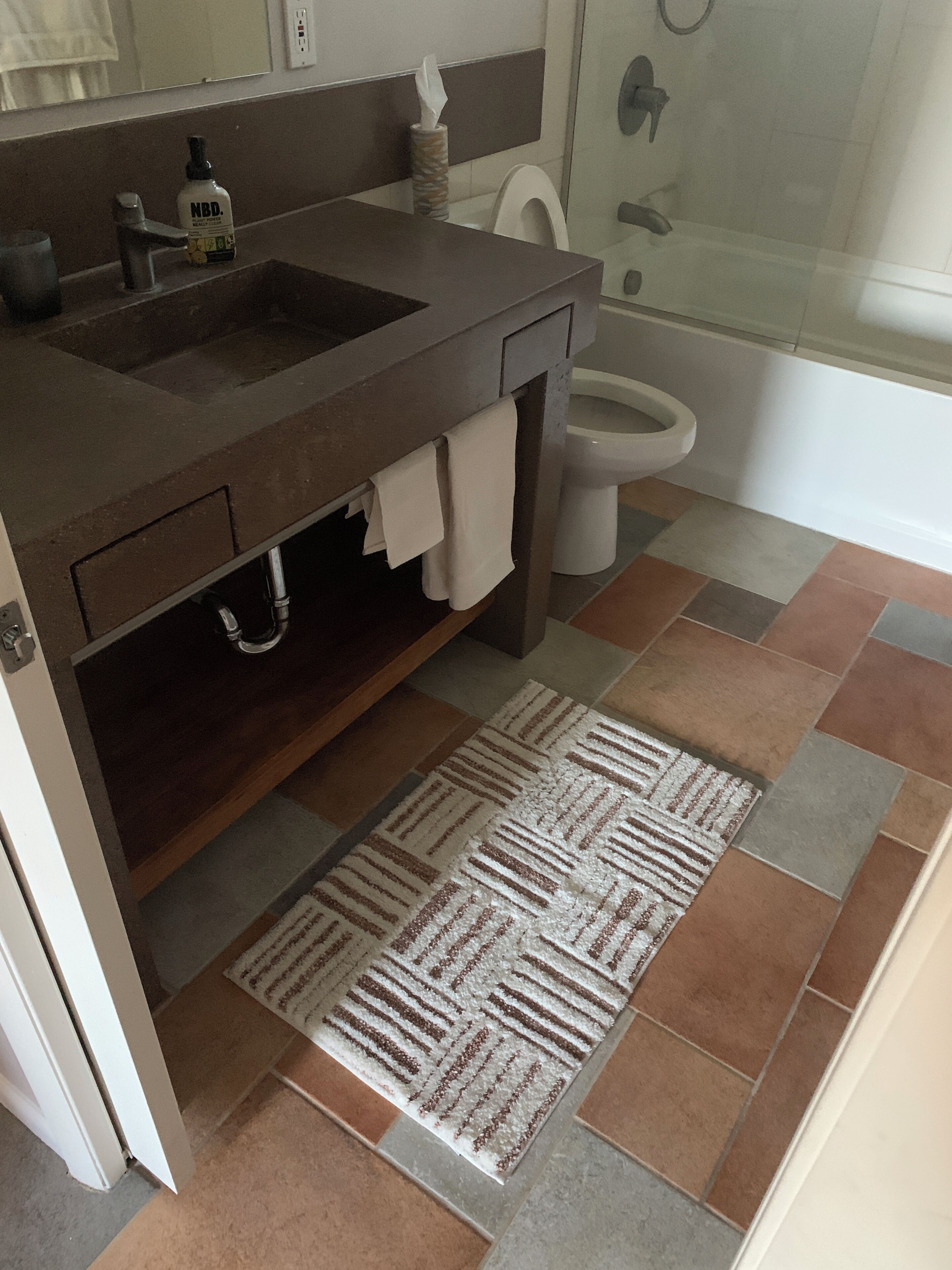Une salle de bain avec un lavabo, des toilettes et une douche.