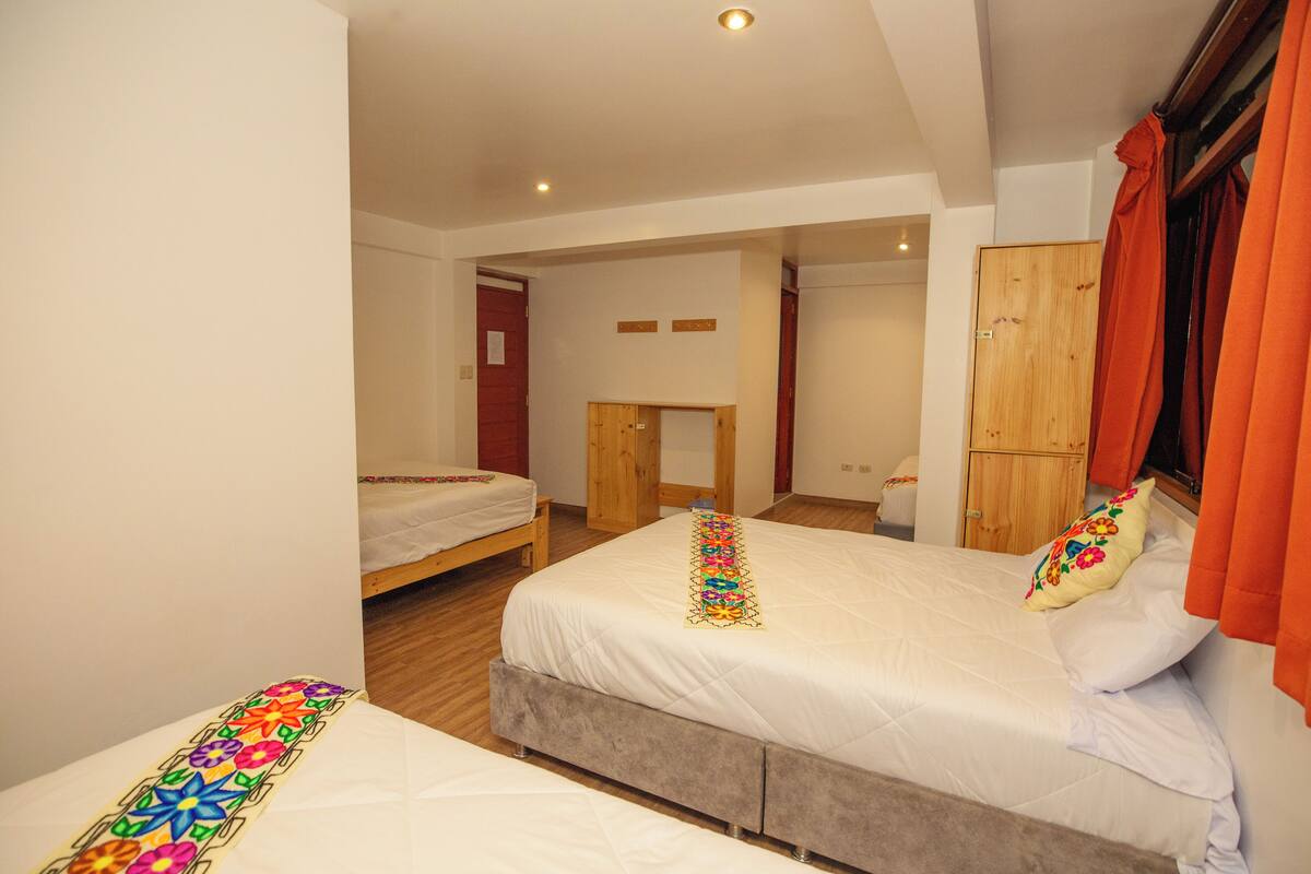Un dormitorio con dos camas, muebles de madera y un escritorio pequeño.
