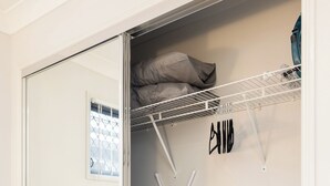 A compact room with a sliding closet door, a laundry basket, a vacuum cleaner, and a mop. - Modern Rocklea 2BR | Near Shops | Parking | 118D2 (Rocklea)