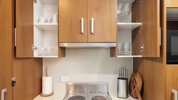 A kitchen with wooden cabinets, a stainless steel stove, and a knife block. - Private Rocklea 1BR | Good Location | 216D1 (Rocklea)
