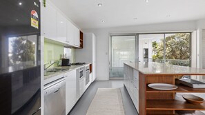 Enjoy cooking in this well-equipped kitchen with a stainless steel refrigerator, oven, and gas stove.