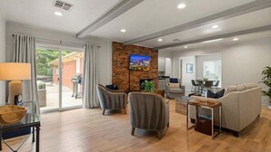 A modern living room with a fireplace, comfortable seating, and a television. - La Casa @ La Fortune/St. Francis (Tulsa)