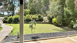A garden with a stone pathway, a small tree, and various shrubs. - Trail Side Cottage (Clare)