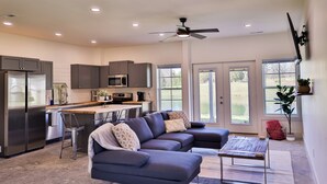 A modern kitchen with dark cabinets, a refrigerator, and a microwave. - Hunts Bend: Feel the Season Change|5-Acre Retreat (Bowling Green)
