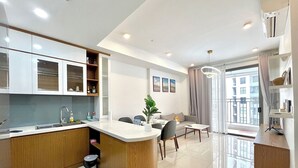 A modern apartment with a kitchen, dining area, and living room. - Golden Apartment (Ho Chi Minh City)