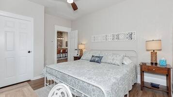 A bedroom with a bed, a nightstand, a lamp, and a ceiling fan.