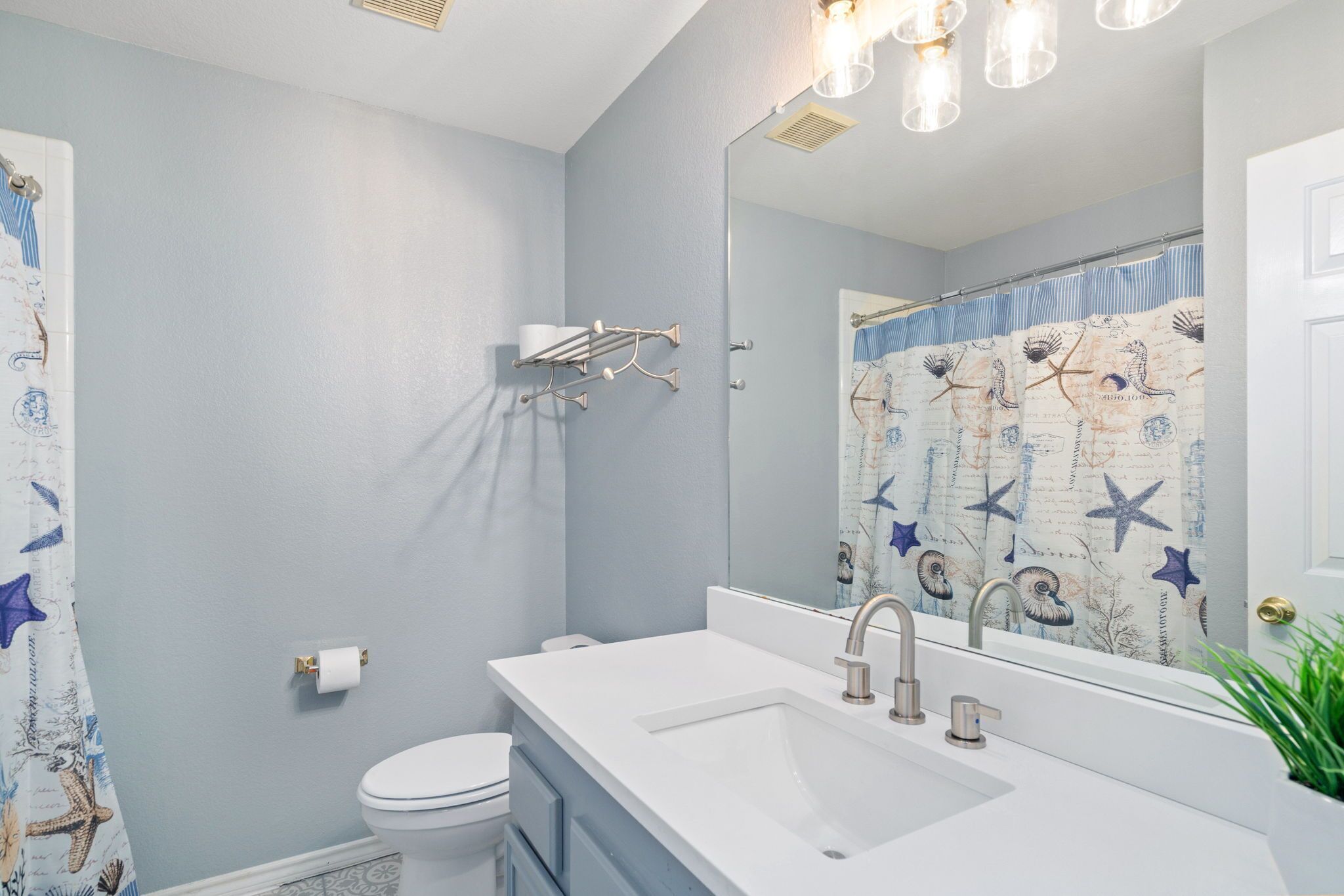 Een badkamer met een witte wastafel, een spiegel en een toilet.