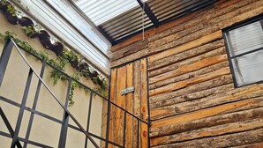 Une cabane rustique avec un escalier en métal et une porte en bois portant l’inscription « Loto Blanche ».