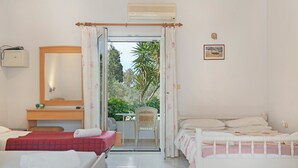 Un dormitorio con dos camas, una silla, una mesita, un espejo y vistas al exterior.