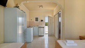 Une chambre d’hôtel avec un lit, une petite kitchenette, une salle de bain et une vue sur l’extérieur.