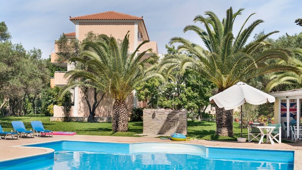 A swimming pool with lounge chairs and palm trees.