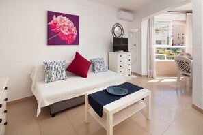 Une chambre à coucher comprenant un lit, une télévision, une commode, une fenêtre avec vue et un balcon.