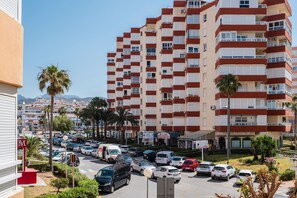Un hôtel à plusieurs étages, doté de balcons, d’un parking et offrant une vue sur les environs.