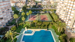 A residential complex with a swimming pool, tennis courts, and palm trees. - Studio Apartment 'Estudio Bloque 84' with Sea View, Wi-Fi and Air Conditioning (Torrox)