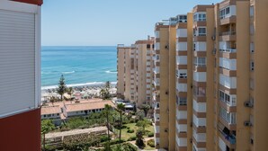 Un immeuble de grande hauteur doté de balcons donnant sur une plage et l’océan.