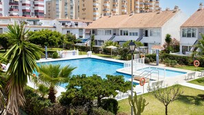 A swimming pool surrounded by greenery, with buildings in the background. - Studio Apartment 'Estudio Bloque 90' with Sea View, Wi-Fi and Air Conditioning (Torrox)
